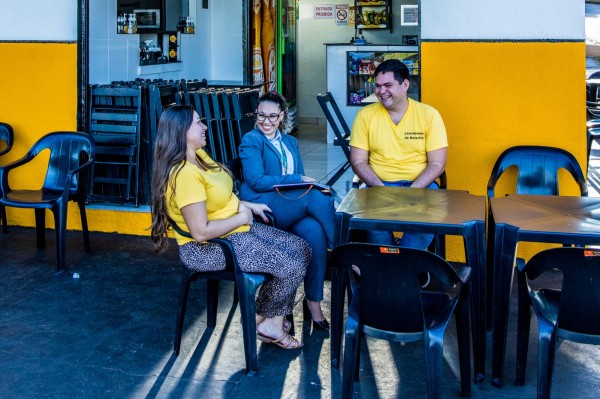 Three people sitting on a café terrace.