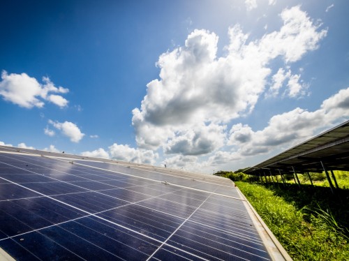 Solar panels and white clouds in a blue sky